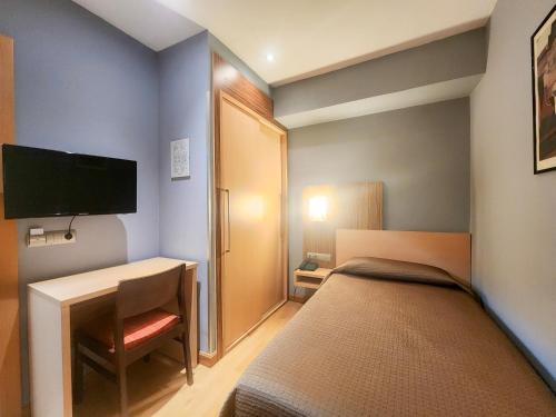 a bedroom with a bed and a desk and a television at Hotel Faranda Alisas Santander, Ascend Hotel Collection in Santander