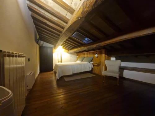 a bedroom with a bed and a white chair at Piazza Duomo casa vacanze in Sutri
