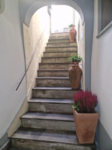 a stairway with two potted plants and two vases at Piazza Duomo casa vacanze in Sutri