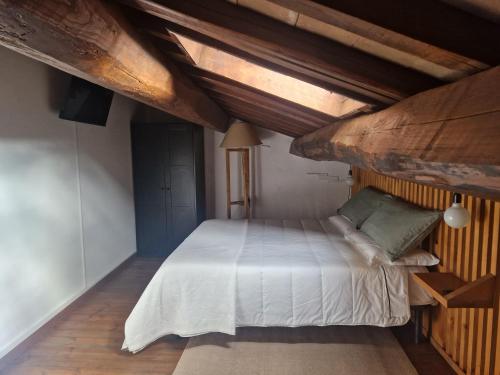 a bedroom with a white bed with a wooden ceiling at Piazza Duomo casa vacanze in Sutri