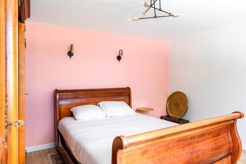 une chambre avec un lit et un mur rose dans l'établissement Ostal périgourdine - Comme à la maison, à Périgueux