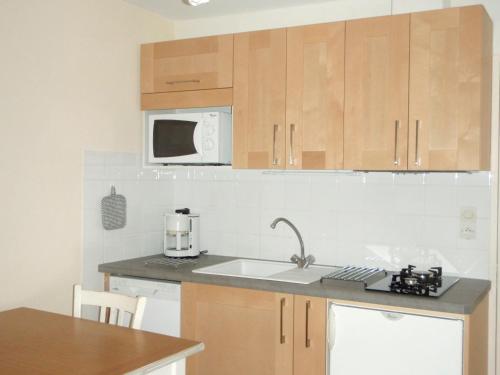 une cuisine avec un évier et un micro-ondes dans l'établissement Le Cadran Solaire Romance classé 3 étoiles et 3 clés, à Sancey-le-Long