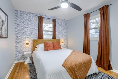 a bedroom with a white bed and two windows at Central 4BD Home - Spacious Backyard & Fun Games in Omaha