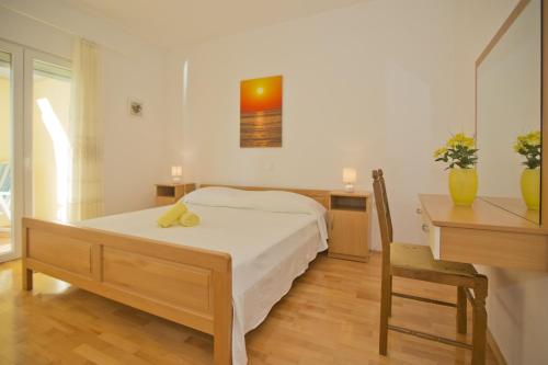 a bedroom with a bed and a desk and a table and chair at Villa Malisko in Hvar