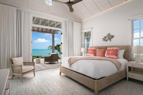 a bedroom with a bed and a view of the ocean at Ambergris Cay - Private Island All-Inclusive in Big Ambergris Cay