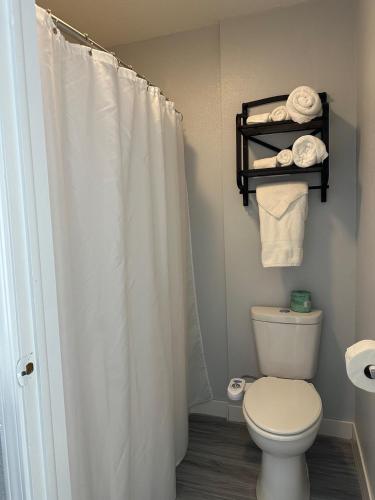 a bathroom with a white shower curtain and a toilet at Motel Tipton in Tipton