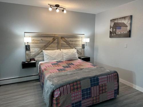 a bedroom with a large bed with a wooden headboard at Motel Tipton in Tipton