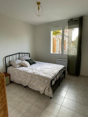 une chambre avec un lit et une fenêtre dans l'établissement Maison familiale, à Saint-Cyr