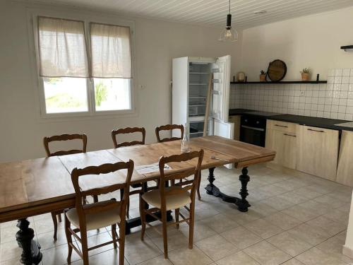 une cuisine avec une table et des chaises en bois dans l'établissement Maison familiale, à Saint-Cyr