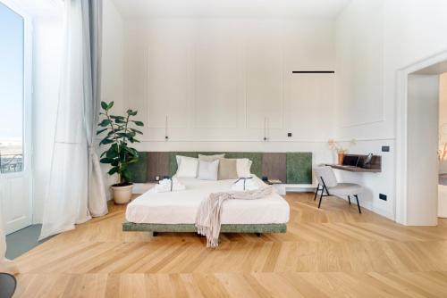 een witte slaapkamer met een bed en een bureau bij THE PLACE Ortigia in Siracusa