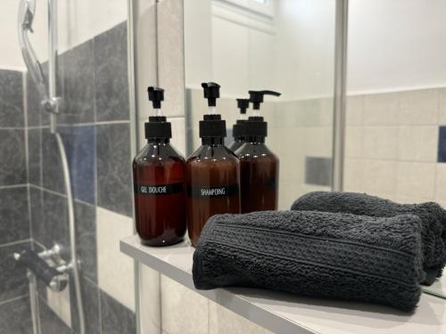 trois bouteilles d'alcool assises sur un comptoir dans une salle de bains dans l'établissement Le Musset, BNBconciergerie, à Vaulx-en-Velin