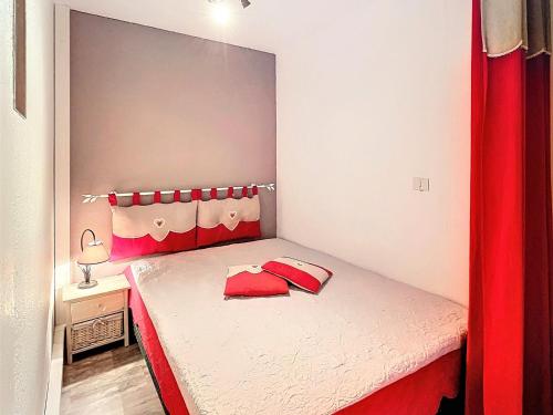 - une petite chambre avec un lit rouge et blanc dans l'établissement Studio rénové · Pied des pistes · Balcon sud · Accès piscine chauffée - FR-1-267-249, à Villarembert