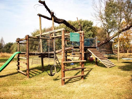 a playground with a swing set and a tree at Tranquility Farmstays in Winterton