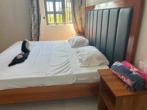 a bed with a wooden frame and white sheets and pillows at Skipper Dan Bungalow in La Gaulette