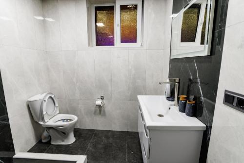 a white bathroom with a toilet and a sink at Ashtarak Venues in Ashtarak