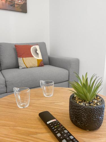 une table basse avec une télécommande et des verres dessus dans l'établissement Design élégant et Parking privé en Hyper Centre, à Blois