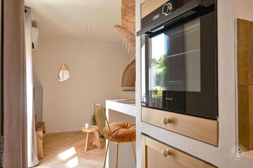 a living room with a kitchen with a microwave at Une perle au bord de l'eau in La Ciotat