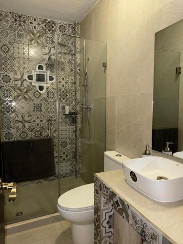 a bathroom with a toilet and a sink and a shower at Suite Boutique #5 Antigua Guatemala in San Pedro Las Huertas