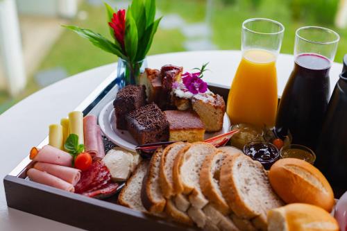 a tray of food with bread and a glass of orange juice at Hotel Sete Ilhas in Florianópolis
