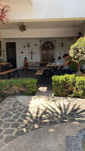 a woman sitting at a picnic table in front of a church at Casa Lomas Grangelo in Atlixco