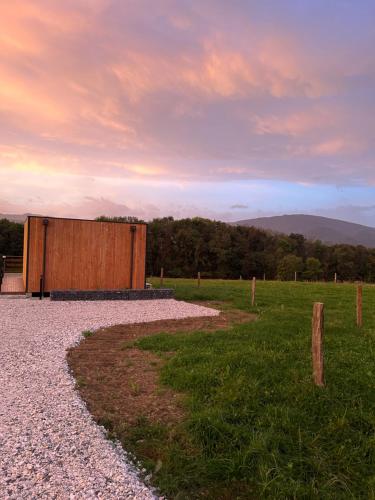 a building in the middle of a field at Le chalet du hameau in Barbazan