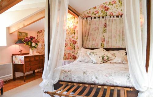 a bedroom with a canopy bed with flowers at Awesome Home In Montaut With Wifi in Montaut