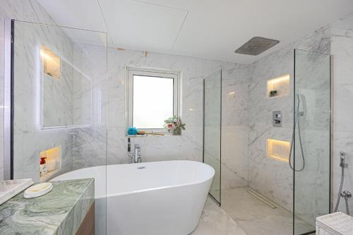 a white bathroom with a tub and a shower at Waterfront Villa at Al Hamra with swimming pool in Ras al Khaimah