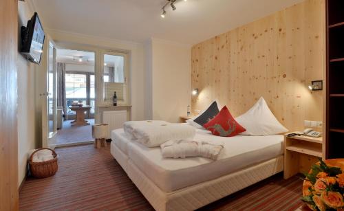 a bedroom with a large white bed in a room at Wohlfühlhotel Schiestl in Fügen