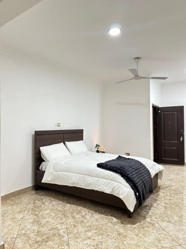een slaapkamer met een groot bed met witte muren bij Luxury 1bedroom apartment in Accra