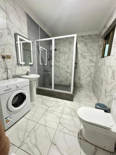 een badkamer met douche en wasmachine bij Luxury 1bedroom apartment in Accra