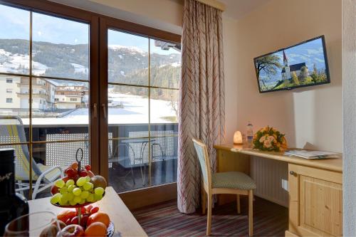 a room with a desk and a window with a view at Wohlfühlhotel Schiestl in Fügen