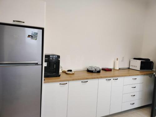a kitchen with white cabinets and a refrigerator at Pensiunea Agroturistica Acvila Apusenilor in Vadu Moţilor