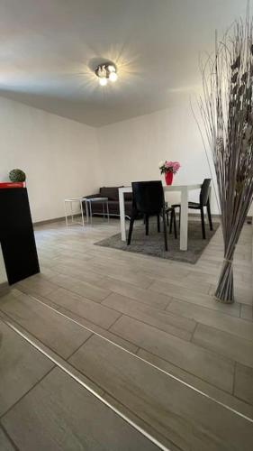 une pièce avec une table et des chaises et une salle à manger dans l'établissement Appartement au calme avec piscine et terrasse, à Carqueiranne