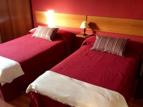 two beds in a hotel room with red walls at Guesthouse RSA by Umbral in Almancil