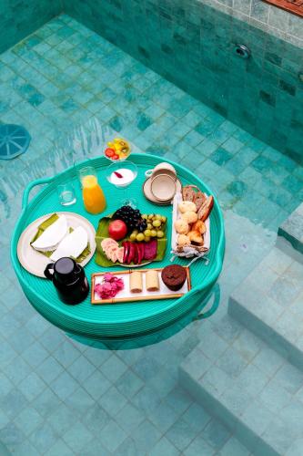 Pousada Oribá Chalé Boutique Milagres - AL في ساو ميغيل دوس ميلاجريس: صينية طعام على طاولة بجوار حمام سباحة