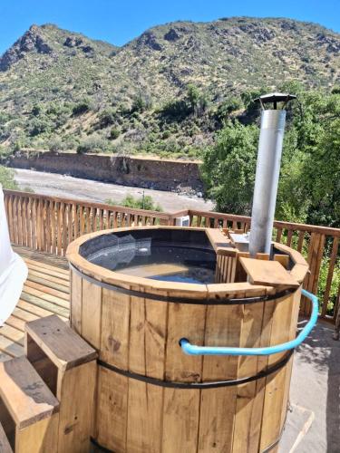 a hot tub on a deck with a mountain in the background at Altos de Guayacan 1 in San José de Maipo