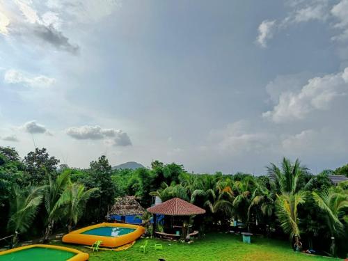 a resort with two swimming pools and palm trees at Leopard Farmhouse in Mhow