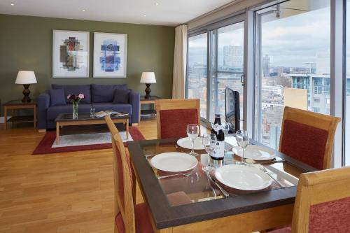 a dining room with a table and a couch at Marlin Aldgate Tower Bridge in London