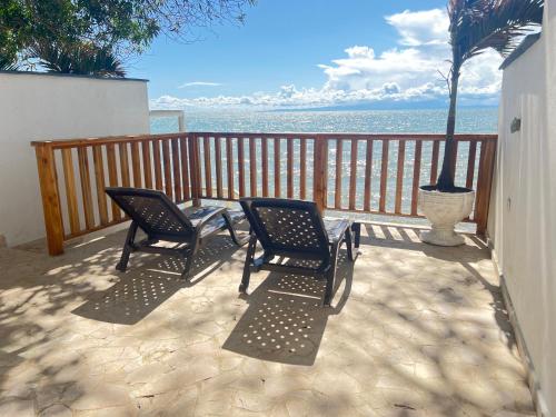 two chairs and a table on a balcony overlooking the ocean at Espectacular alojamiento frente al mar in Necoclí