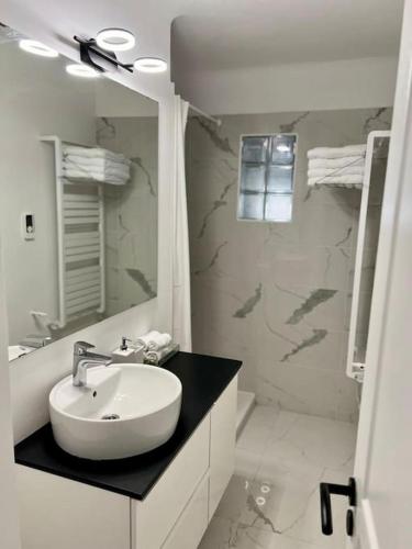 une salle de bain blanche avec un lavabo et une douche dans l'établissement Le B Plage, Appartement 4 Personnes, Climatisation, Parking, à Antibes