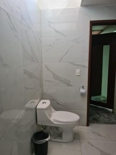 a white bathroom with a toilet and a mirror at Estancia Monraz in Guadalajara