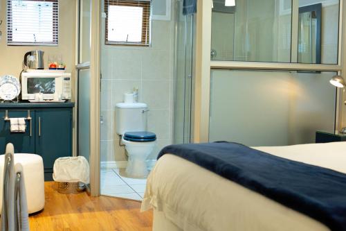 a bathroom with a bed and a toilet in a room at Crisp Guest Rooms in Bloemfontein