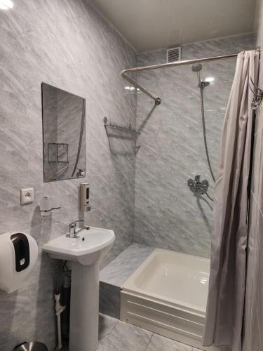 a bathroom with a shower and a sink and a tub at The RISE HST in Tashkent