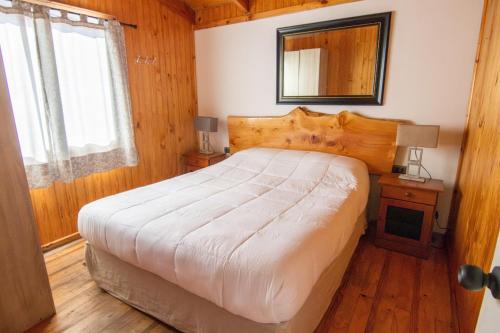 a bedroom with a large bed and a mirror at Altos de Pichilemu in Pichilemu