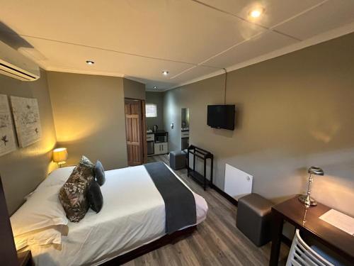 a hotel room with a bed and a television at Crisp Guest Rooms in Bloemfontein