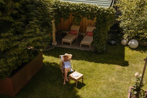 Una bambina seduta su una sedia in un giardino di Hotel Goldener Ochs a Bad Ischl