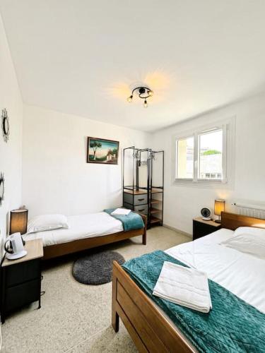 une chambre avec deux lits et une fenêtre dans l'établissement Le Floreal, Apt 4 Prs, 400m plages, stationnement, à Antibes