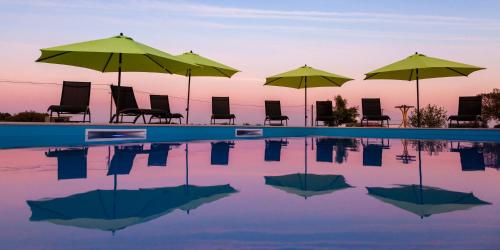 a group of chairs and umbrellas next to a pool at Monte Farropo in Monsaraz