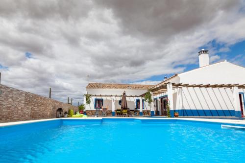 a large blue swimming pool in front of a house at Monte Farropo in Monsaraz