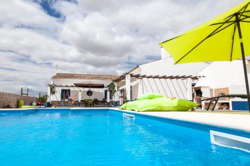 una piscina con una sombrilla amarilla y una piscina en Monte Farropo, en Monsaraz